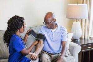 Young African Male Cyclist Lying On Street After AccidentSenior, man or face of nurse in nursing home for support, wellness or healthcare in wheelchair with laugh. Elderly, person and caregiver or professional with portrait for retirement or care in lounge