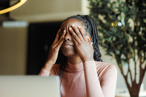 Young unhappy African woman with dreadlocks crying covering eyes with hands in coffee house closeup. Depressed black girl suffering, despaired, upset. Tiredness, unfair, troubles.