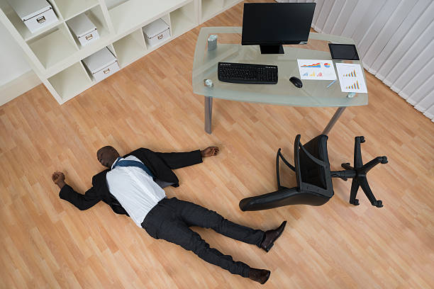 Unconscious Young African Businessman Lying On Floor In Office